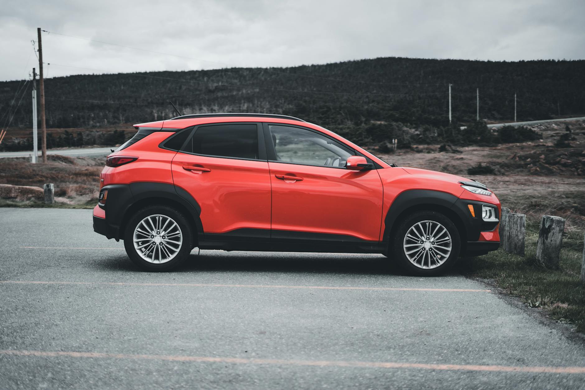Czerwony SUV Hyundai Tucson zaparkowany na zewnątrz w pochmurny dzień