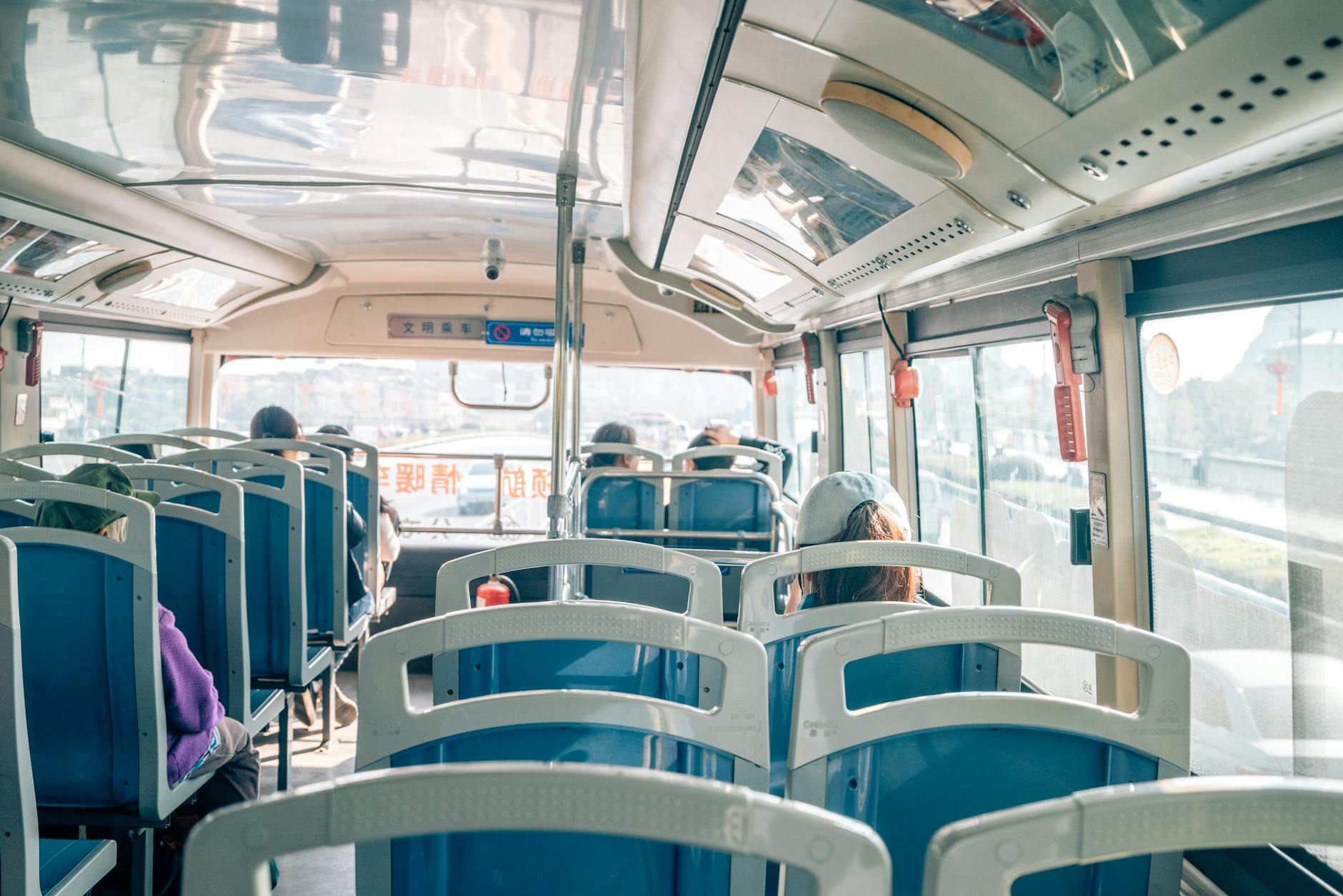 Pasażerowie w słonecznym wnętrzu autobusu podczas podróży