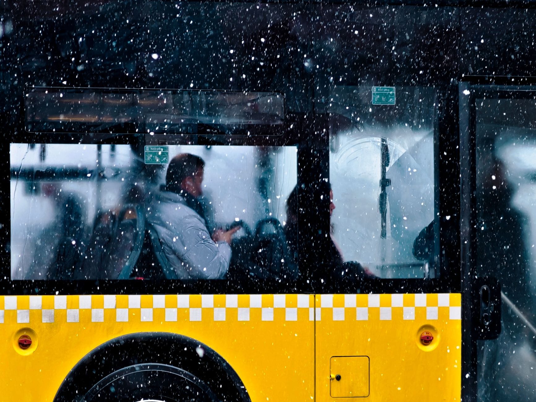 Podróżny w żółtym busie podczas śnieżycy w europejskim mieście